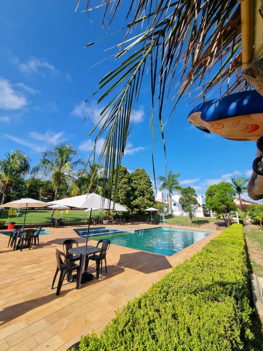 Mesas e cadeiras ao lado da piscina