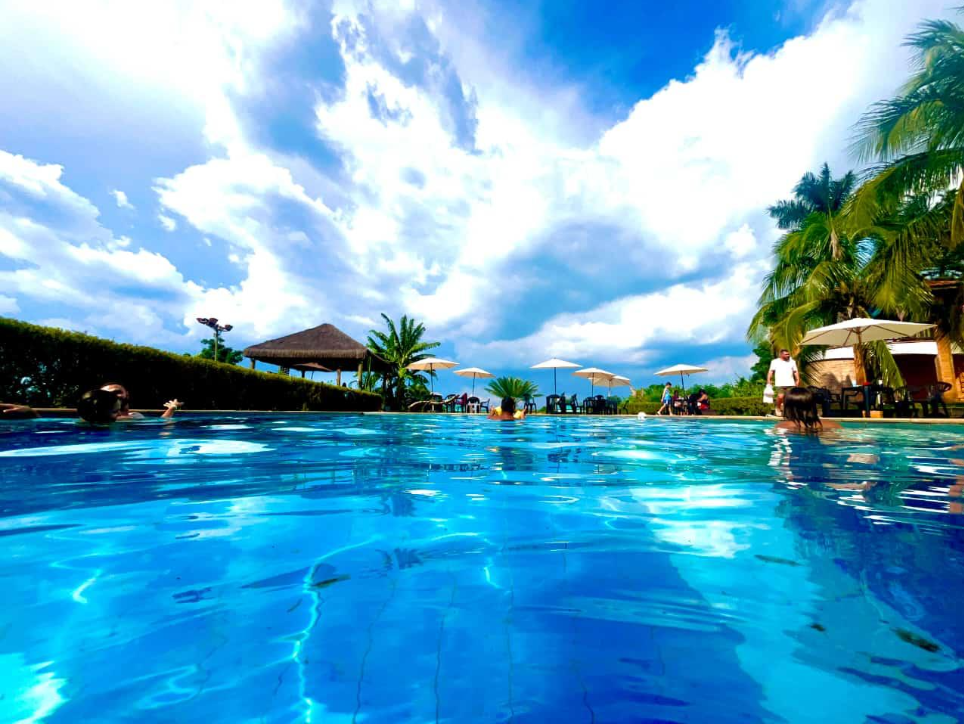 Piscina com pessoas se divertindo e quiosque